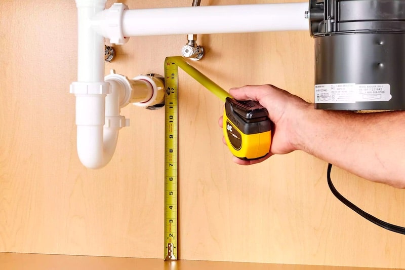 A plumber using a measuring tape