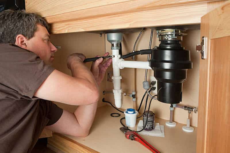 A plumber installing a drain 