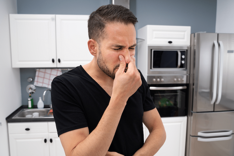 A man holding his nose in disgust 