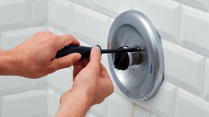 A plumber fixing a faucet 