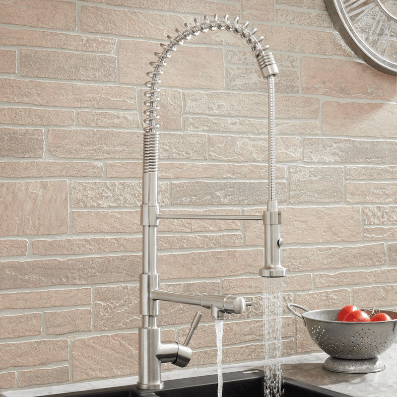 A silver faucet near a bowl of tomatoes 