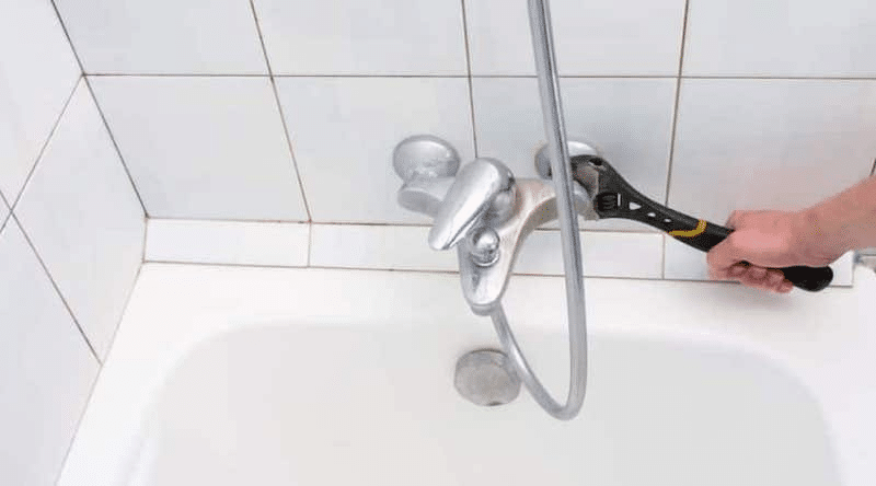 A plumber fixing a faucet 