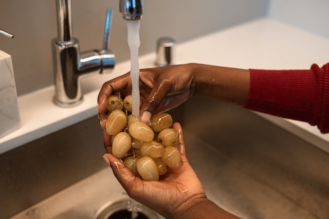 A person washing grapes