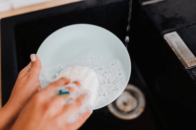 A person washing some plates