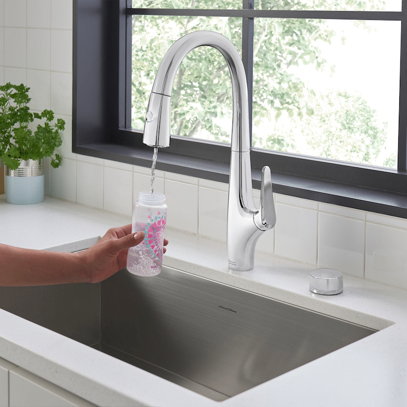 A woman filling a cup up with a faucet