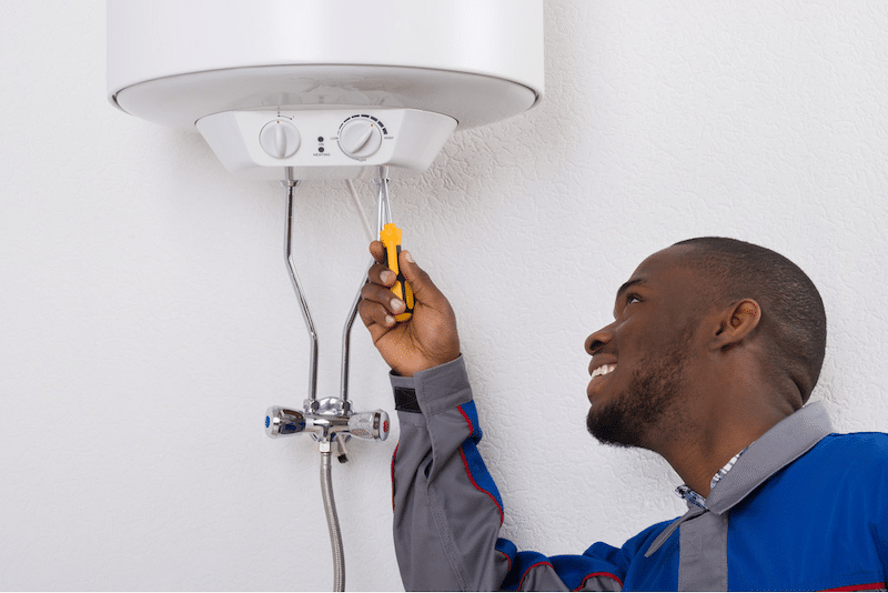 A plumber fixing a water heater