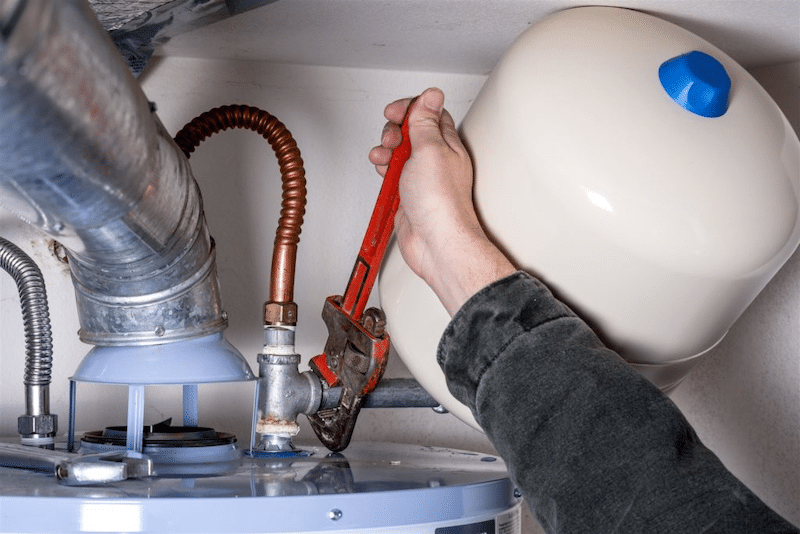 A plumber fixing a water heater