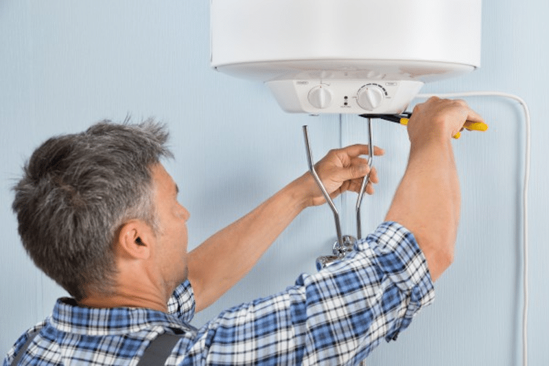 A plumber fixing a water heater