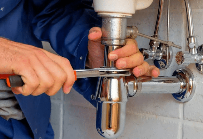 A plumber fixing a stainless steel drain 