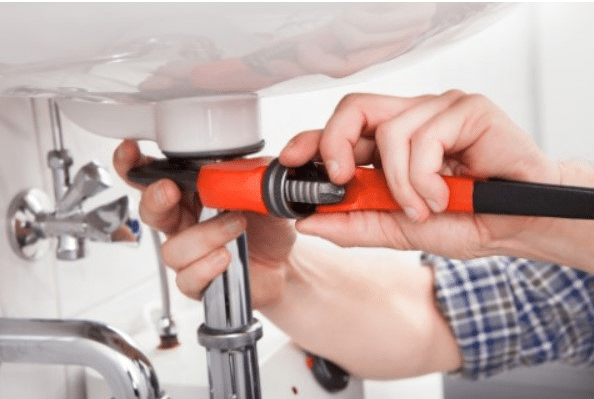 A plumber fixing a drain 