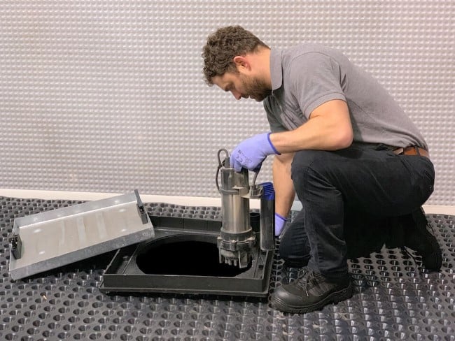 A plumber installing a sump pump