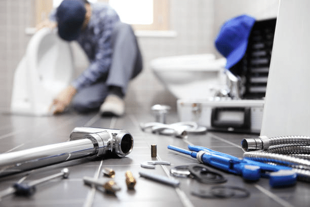 A plumber fixing a toilet 