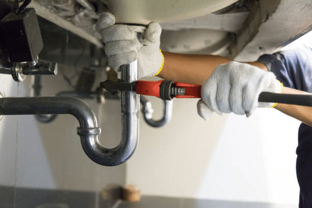 A plumber fixing a drain 