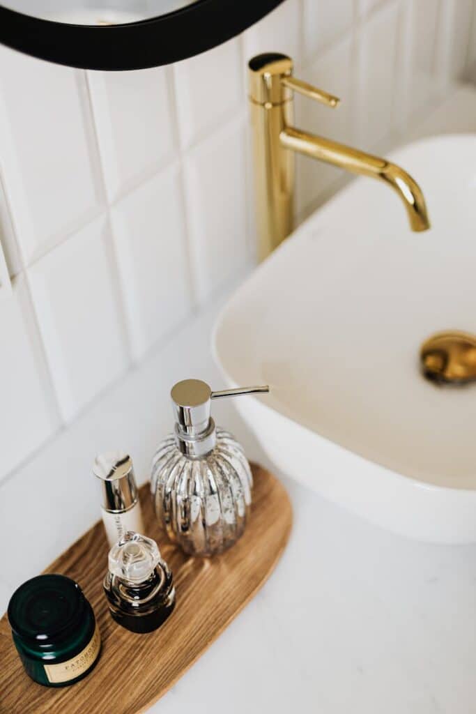 Set of stylish cosmetic products placed near sink in bathroom