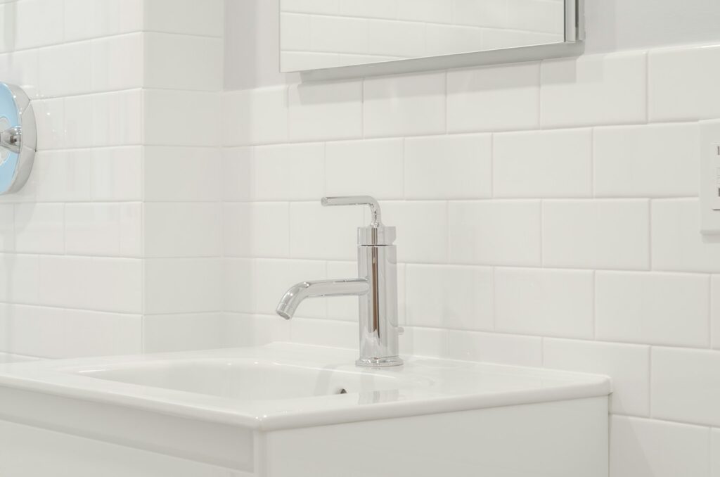 stainless steel faucet on white ceramic sink