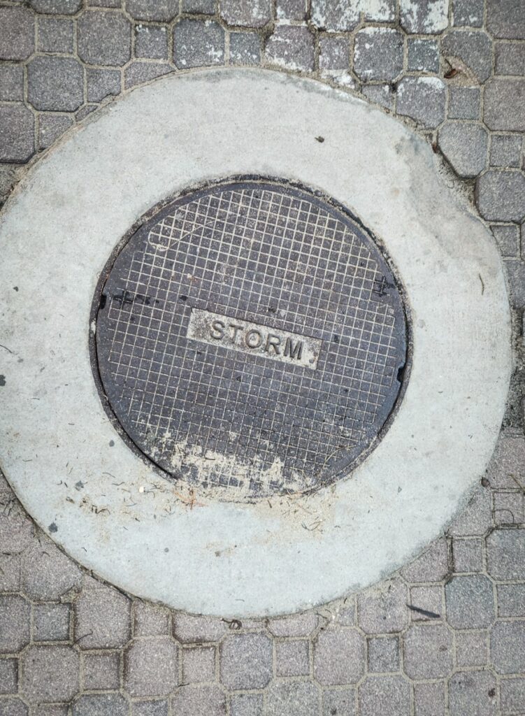 A manhole cover on a brick sidewalk