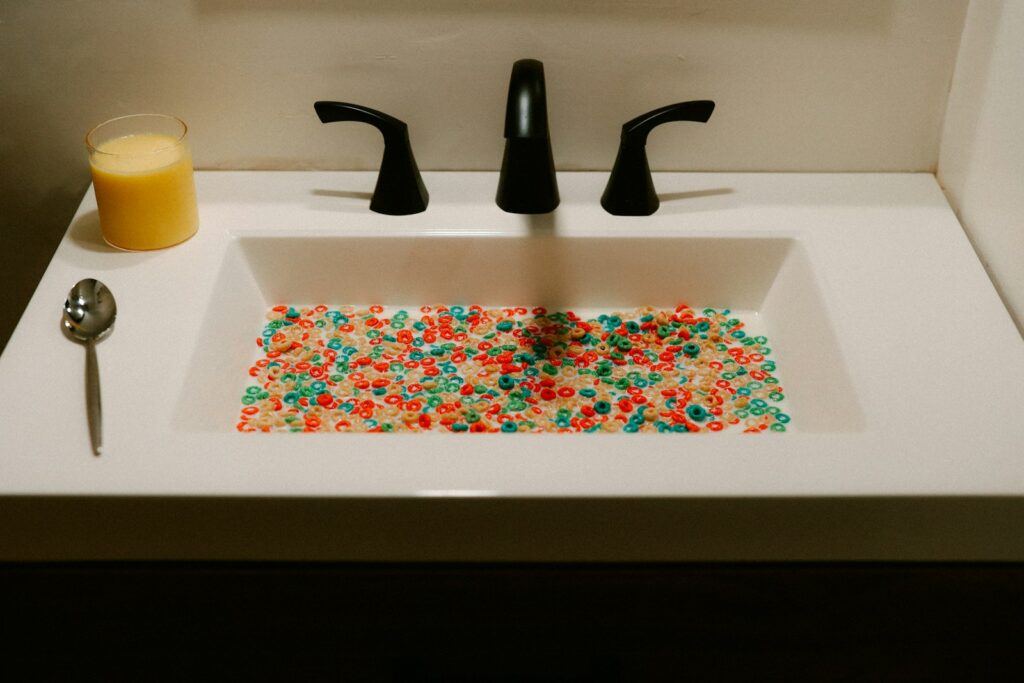 The bathroom sink is filled with colorful beads.