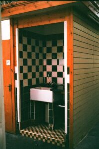 A small room with a sink and checkered tiles