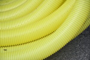 A coiled yellow flexible ribbed tube