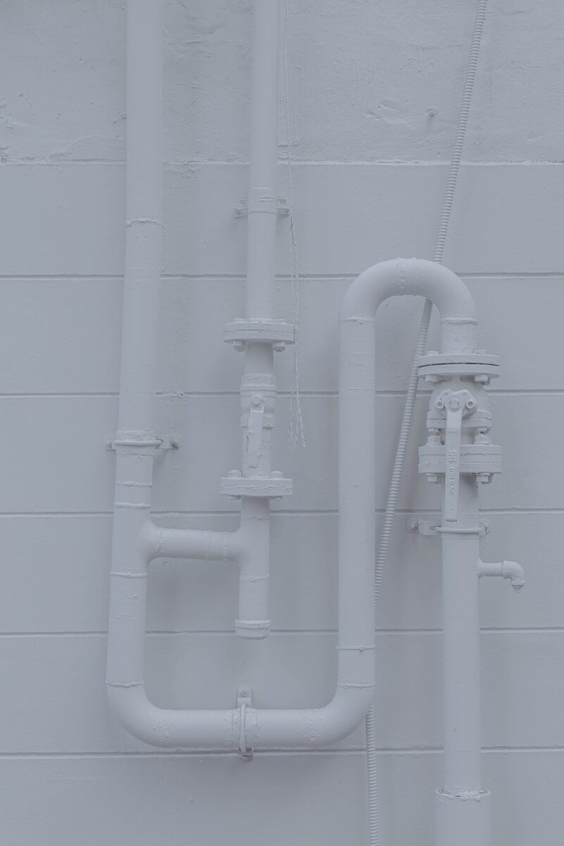 a white wall with pipes attached to it