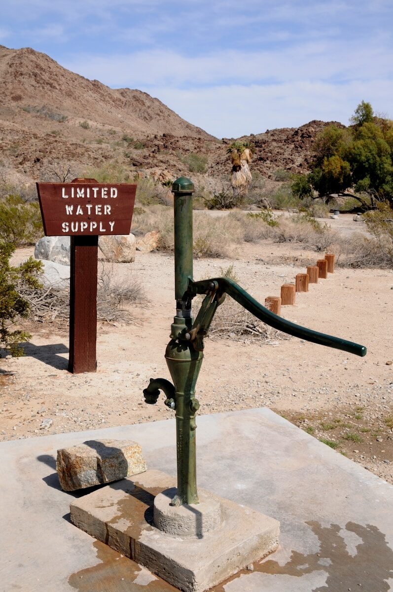 Old water pump with limited supply sign