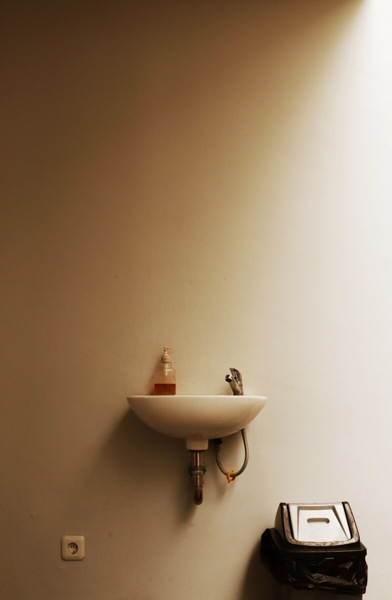 Photo by Evan Marvell A sink with soap dispenser and trash can
