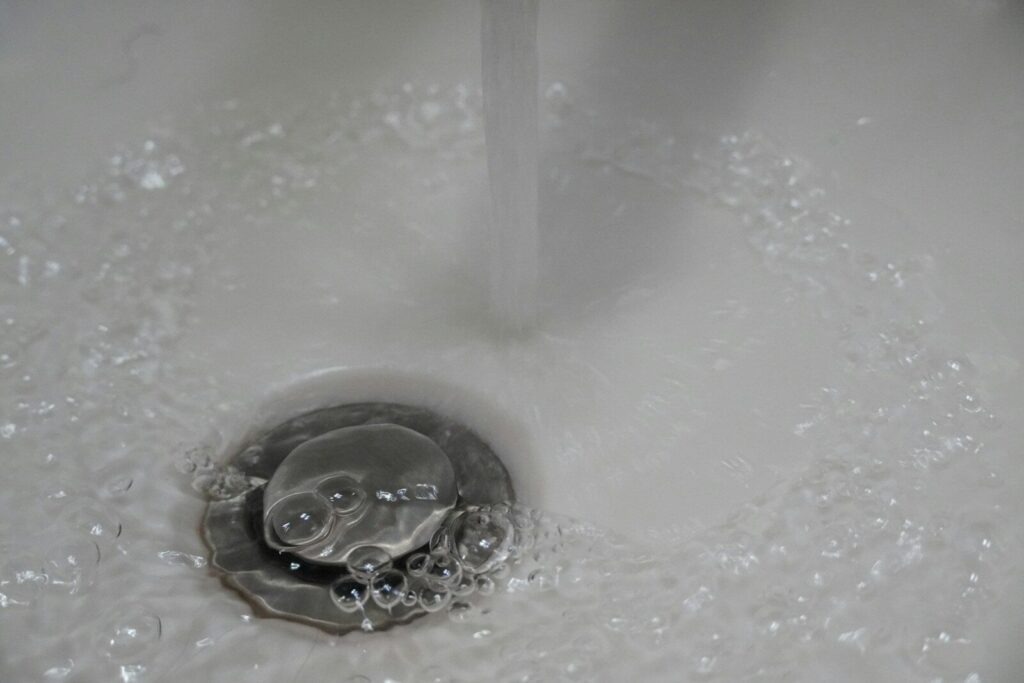 a close up of a sink with water running down it